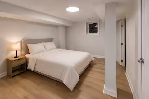 Bedroom with white bedding and a bedside lamp